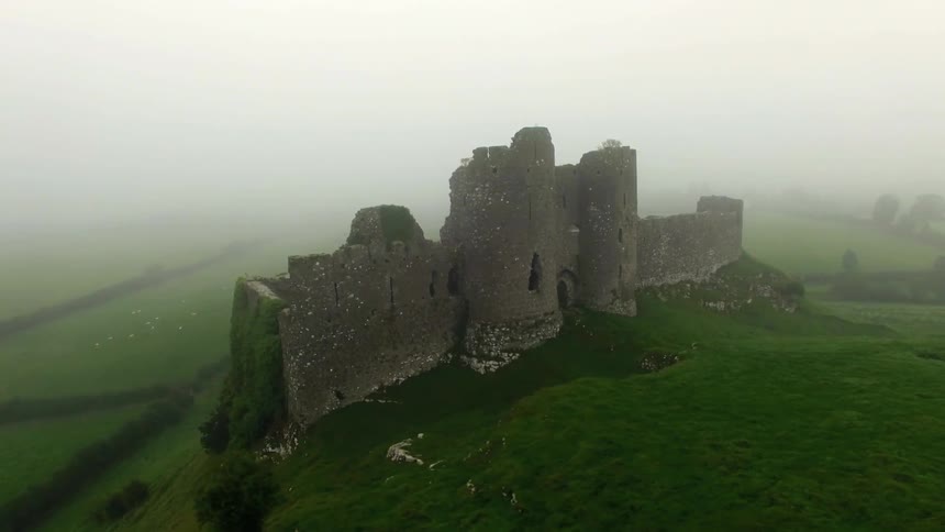 A castle sits on a lush green hilltop