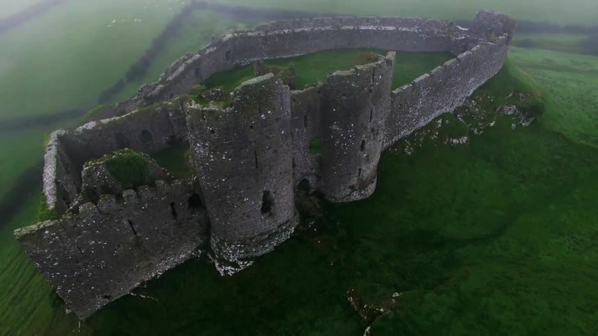 A castle sits on a lush green hilltop