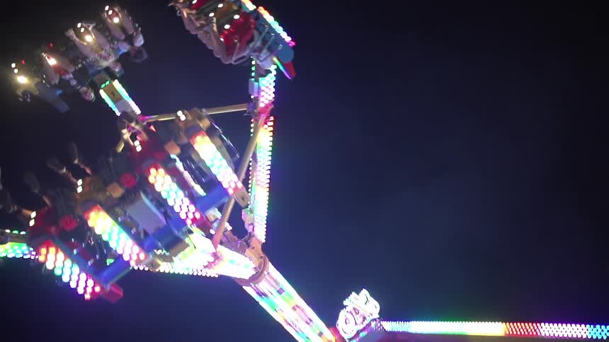 An amusement ride with heavy lights moves around