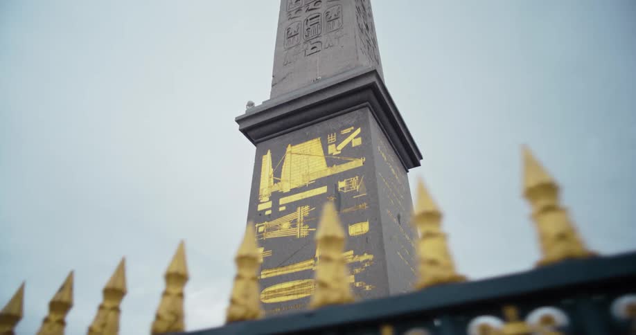 Shot of the luxor obelisk in paris focusing on the monuments intricate carvings and golden adornments against a cloudy sky