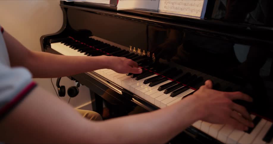 Pair of hands of a person playing the piano