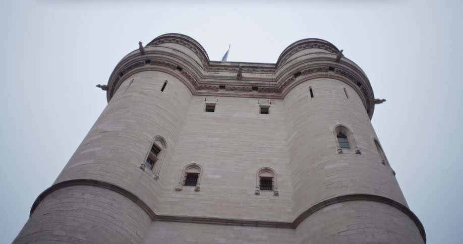 A low angle shot of a historic stone turret with intricate carvings and a clean sky
