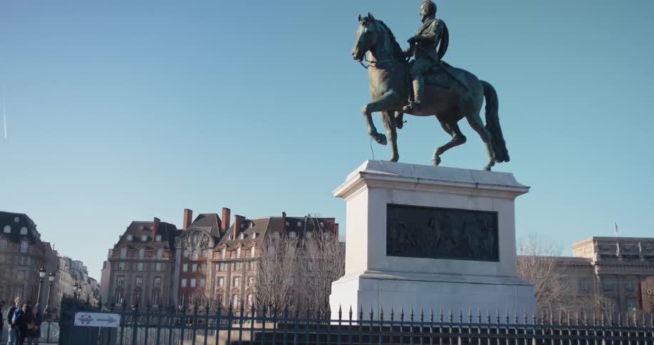 Equestrian statue of a man on a pedestal in a square surrounded by historic buildings