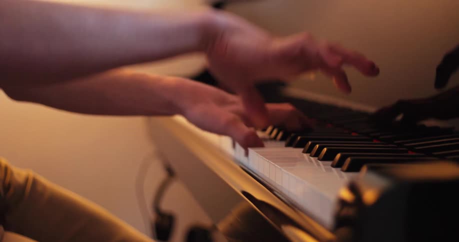 A closeup shot of a persons hands skillfully playing a yamaha piano