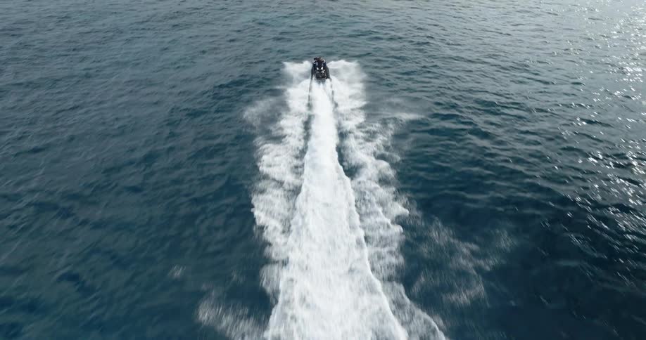 Person riding a jet ski across a vast blue ocean