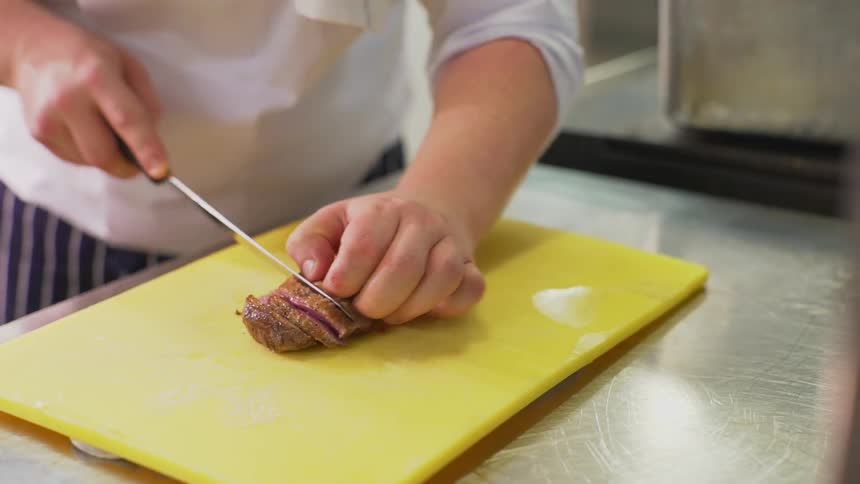 A chef slices some meat