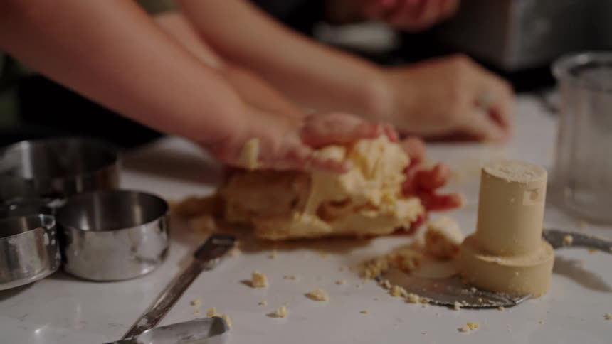 Hands kneading dough on a kitchen counter