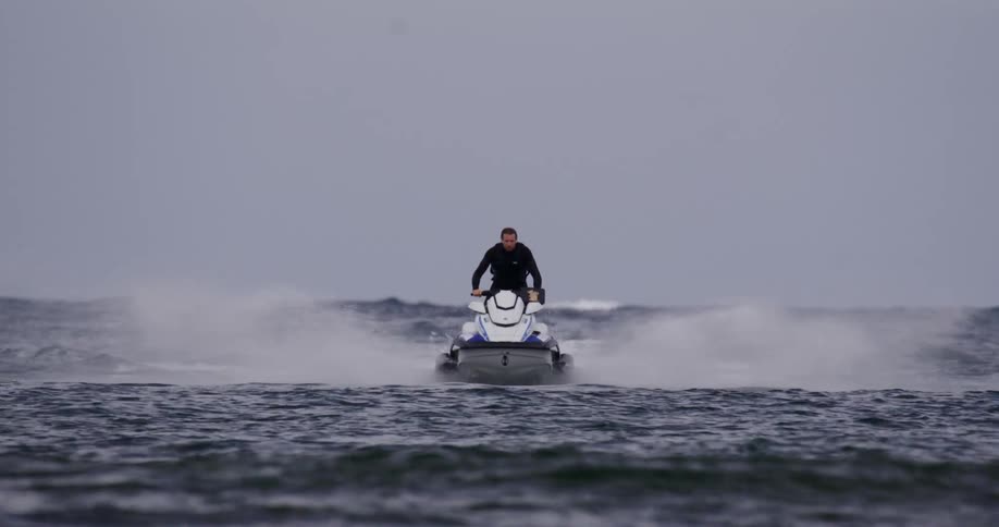 A man speeds across the ocean on a jet ski