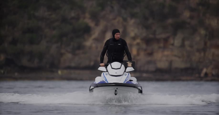 A person rides a jet ski across the water