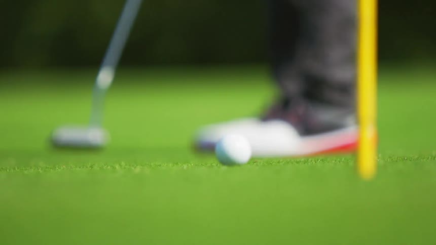 A golfer putts a shot