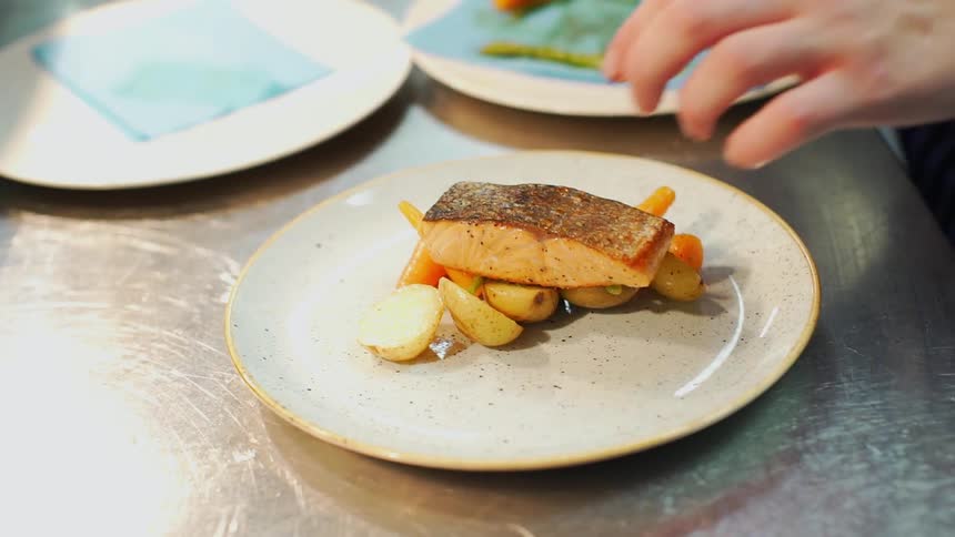 A chef arranges a plate of food