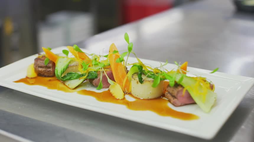 A plate of food sits atop a stainless steel counter