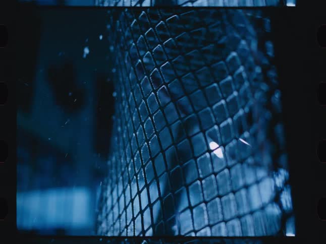 A close up of a hockey net being hit with a puck inside a dimly lit sports venue
