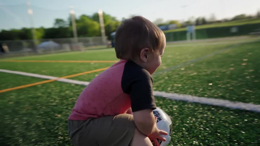 Little boy playing with a soccer ball on an artificial lawn