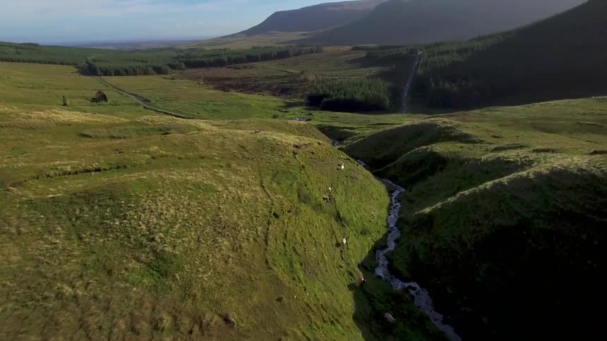 The hills below have sheep walking along