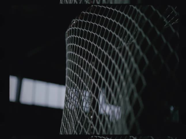 A closeup view of a hockey net as a puck is shot into it causing the netting to slightly move