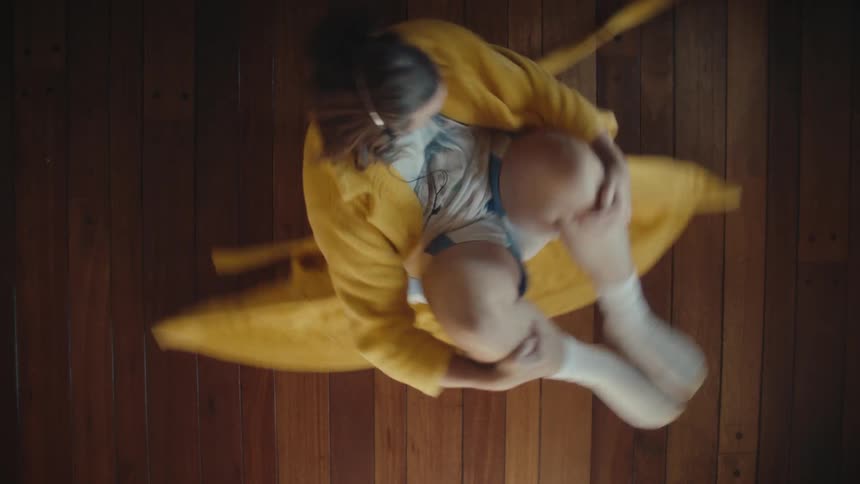 Man wearing headphones briefly spins on the wooden floor