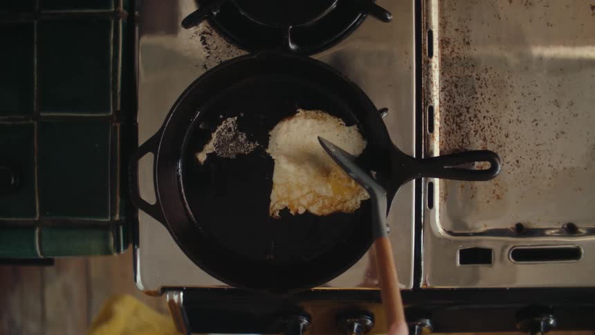 A person is cooking an egg on a pan