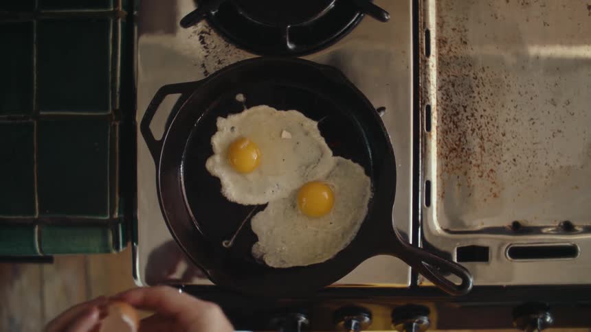 Eggs are cracked into the pan and cooked