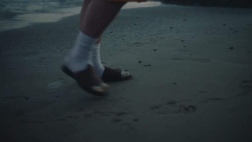 Person walking along the beach at sunset