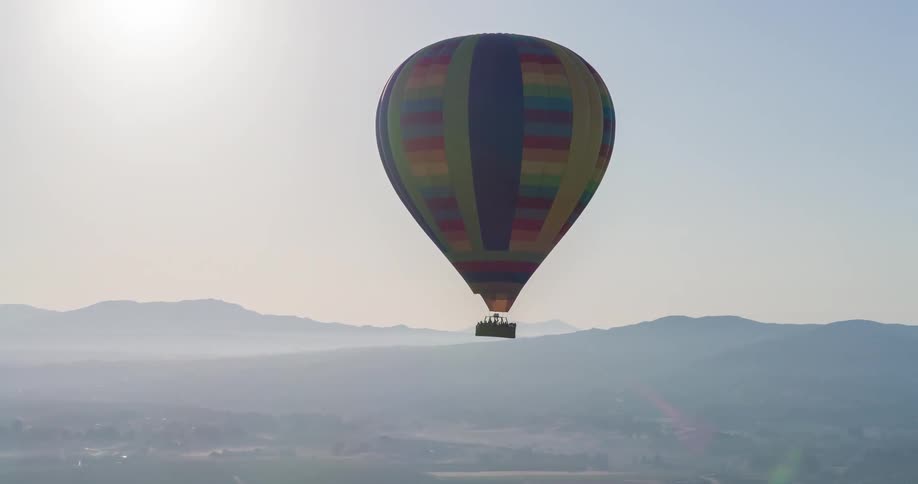 Colorful balloon flying with mountains on the horizon