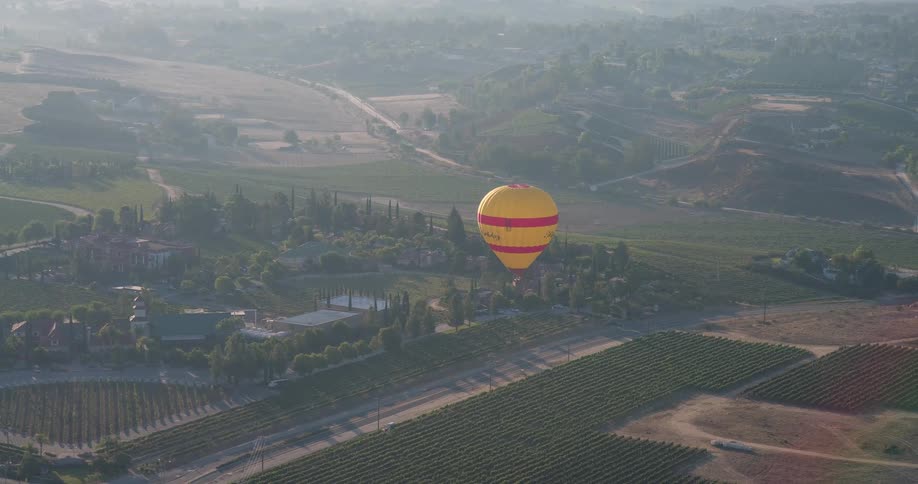 Yellow balloon flying over an agricultural area