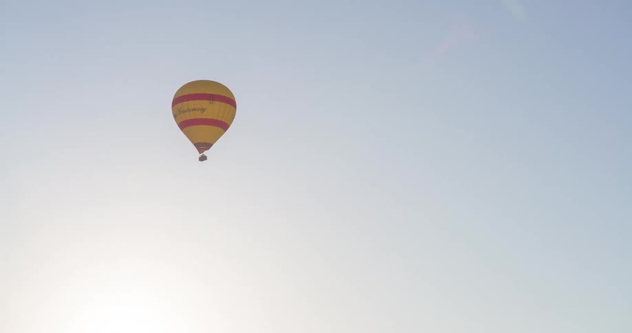 The hot air balloon is in the cloudy sky