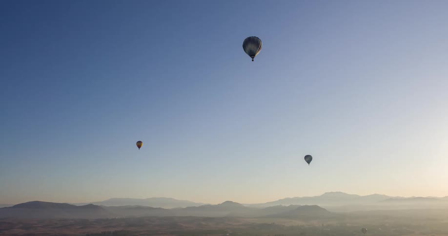 Hot air balloons fly high in the sky