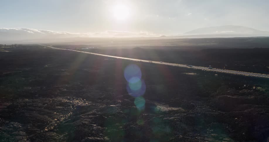 Aerial shot of a highway with vehicle traffic and the sun on the horizon