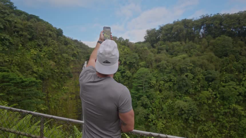 The man uses his phone to photograph the mountain