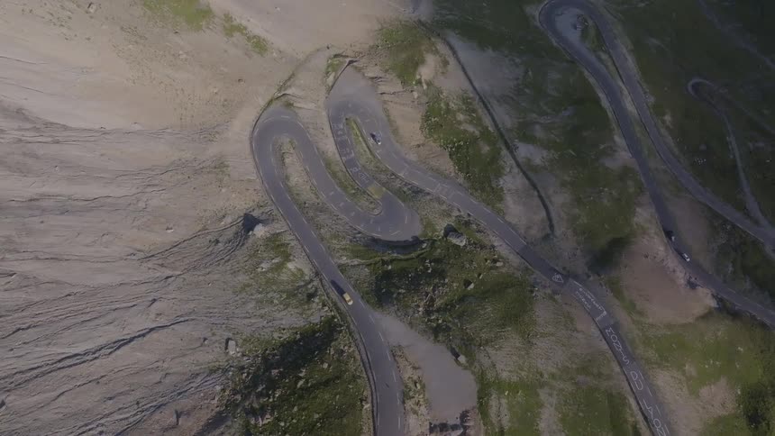 Winding road cutting through an arid mountainous area