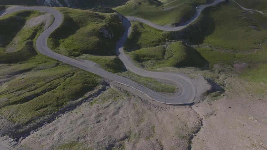 Winding road cutting through hills covered with vegetation