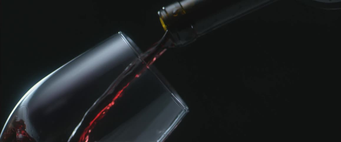 Red wine is poured into a glass