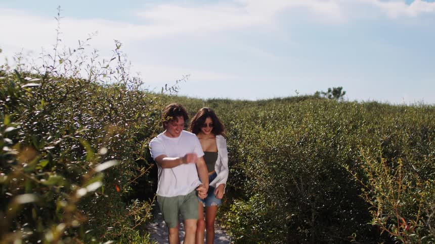 Couple standing among vegetation looking at each other and smiling