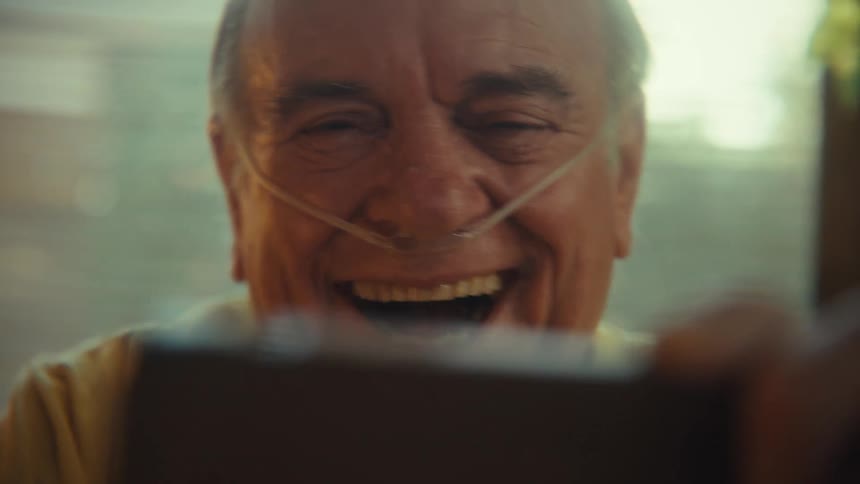 A man cheers at something on his phone