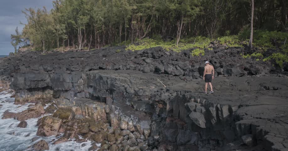 A man stretches on the cliff over the ocean