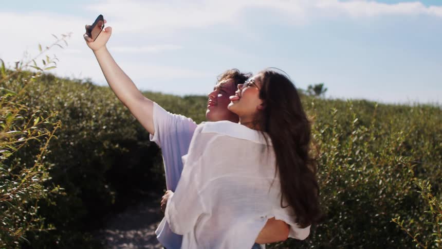 A couple take selfies in nature
