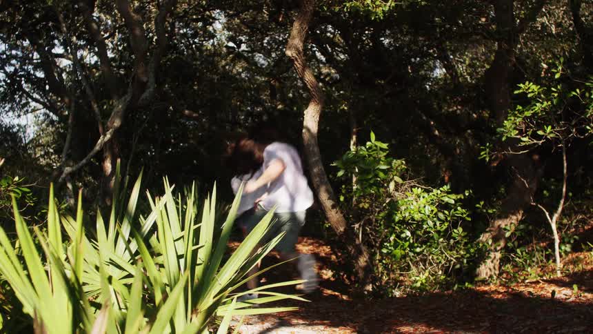 Couple walking on a trail surrounded by dense vegetation