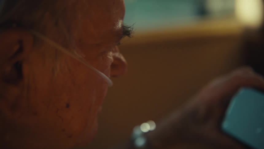An old man looks at a phone screen