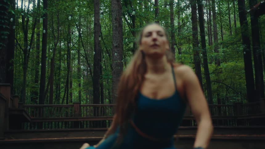 Woman outdoors in a forest doing stretching