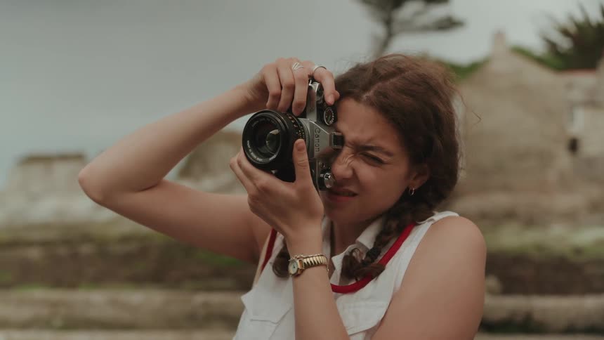 A photographer focuses her vintage 35mm camera