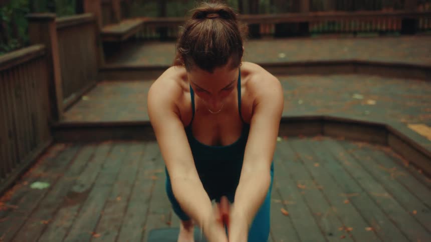 The woman is doing yoga on her deck