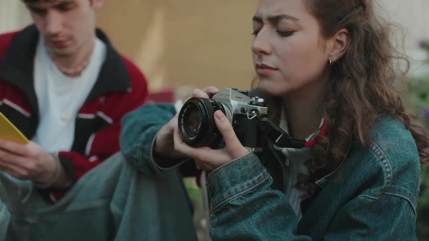 Woman taking a picture with a film camera