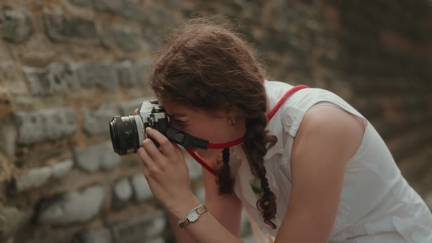 A woman focuses her camera