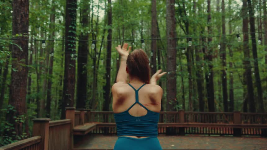 Woman outdoors in a forest doing yoga