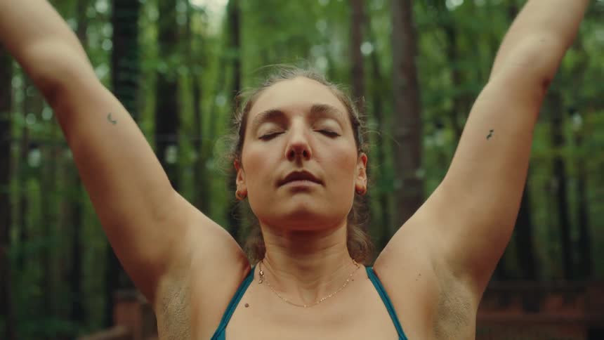 Woman outdoors in a forest doing yoga moves