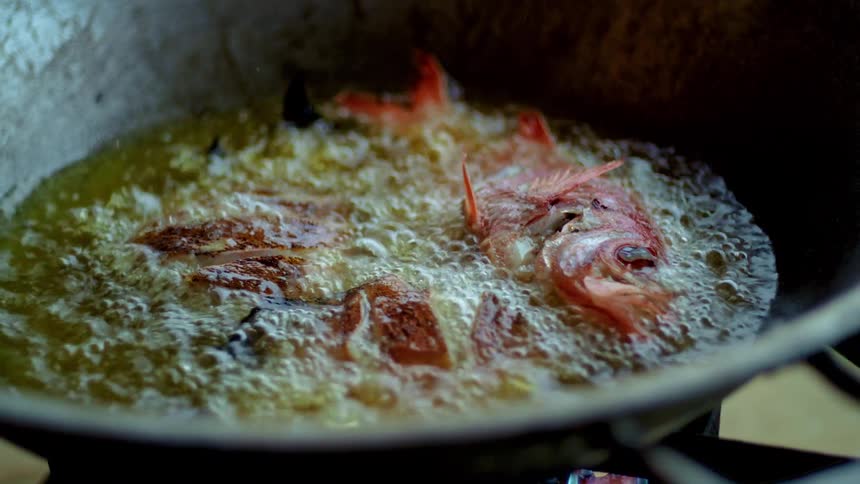 A fish grilling in a pan