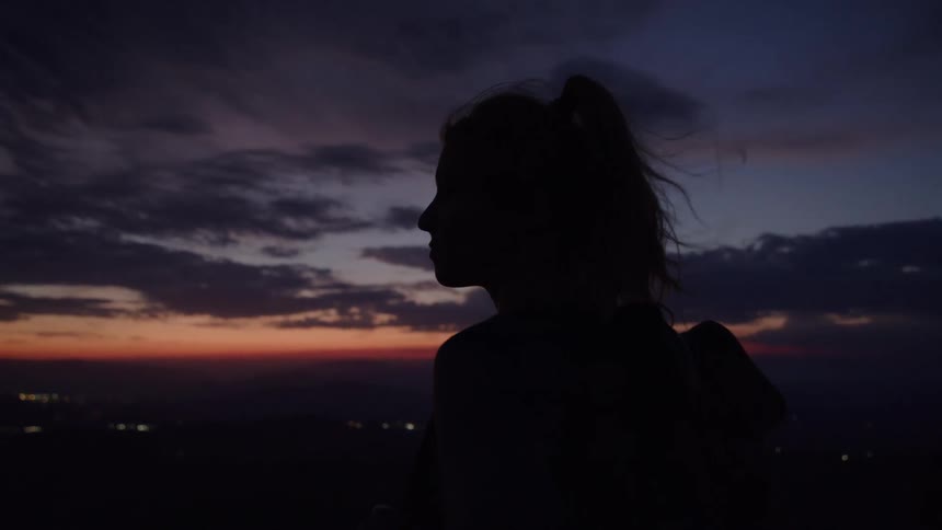 Silhouette of a person with a backpack at sunset