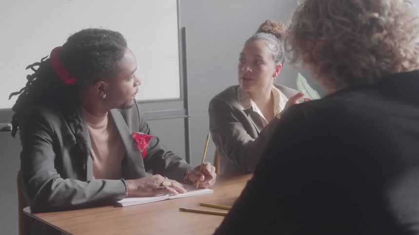 Coworkers talk together at the desk
