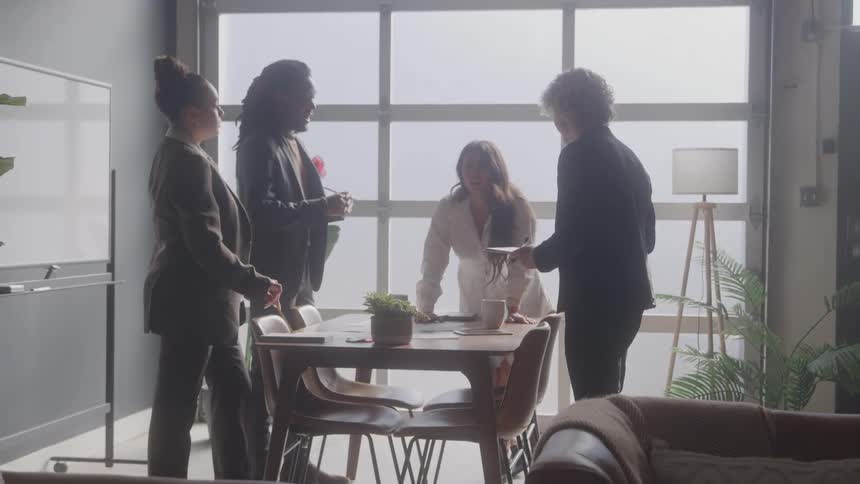 Four people around a table in an office meeting
